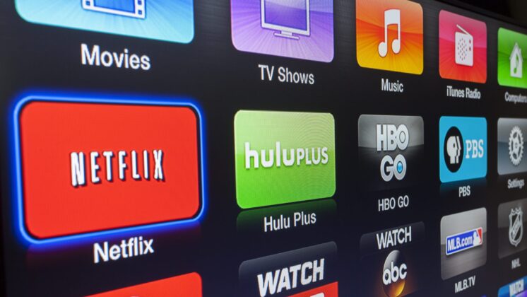 An Apple TV interface displaying Netflix, Hulu, and a variety of other apps.