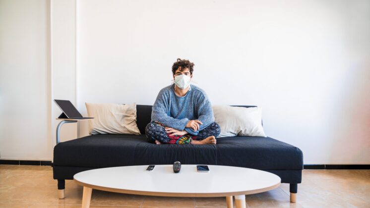 Young man sits indoors during COVID-19 quarantine