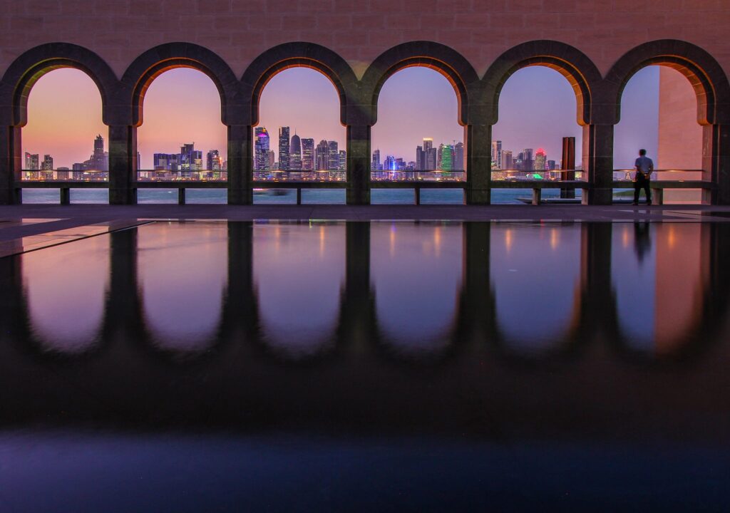 The Doha, Qatar skyline at twilight through museum arches