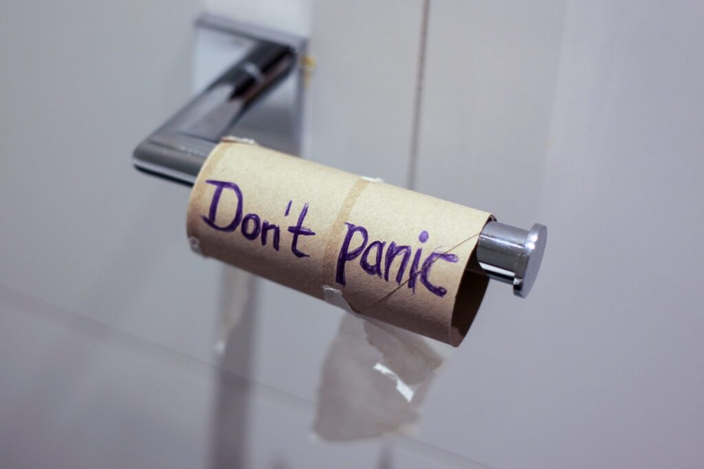 Empty toilet paper roll reading "don't panic"