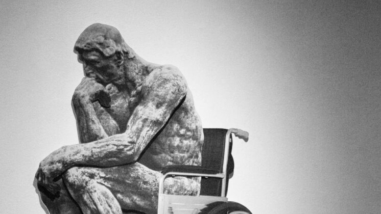 Thinker, a famous sculpture by Rodin, has be photoshopped into a wheelchair.