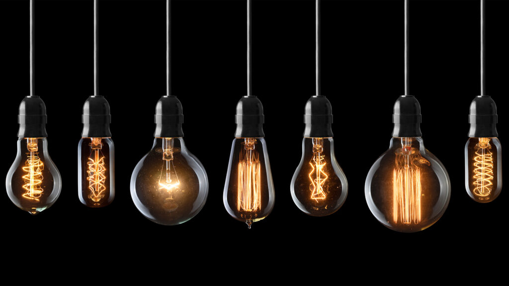 Old-fashioned lightbulbs lined up on a black background, symbolizing a soft presentation style