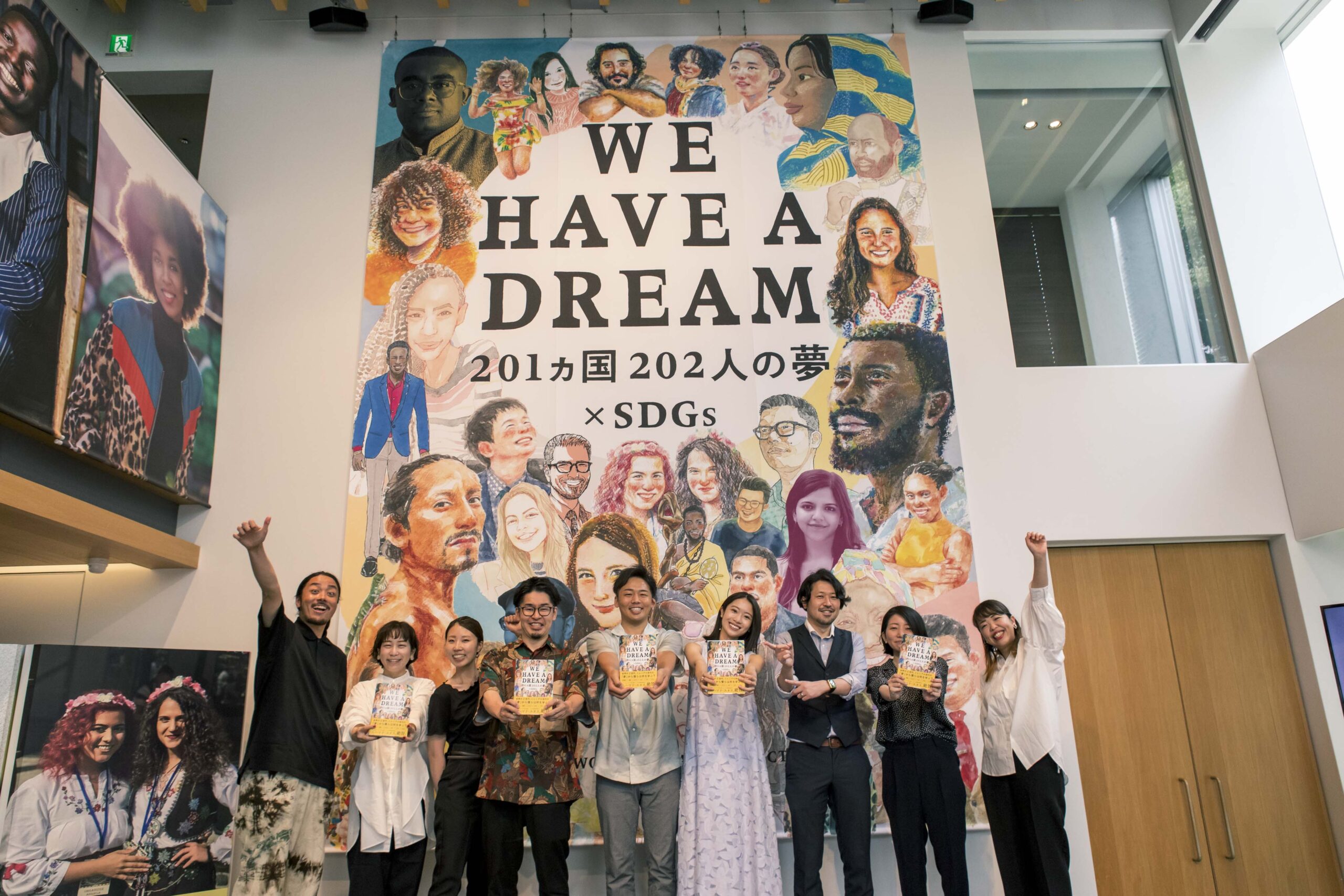 An image of the launch party for WE HAVE A DREAM with the publishing team standing before a large banner of the book cover