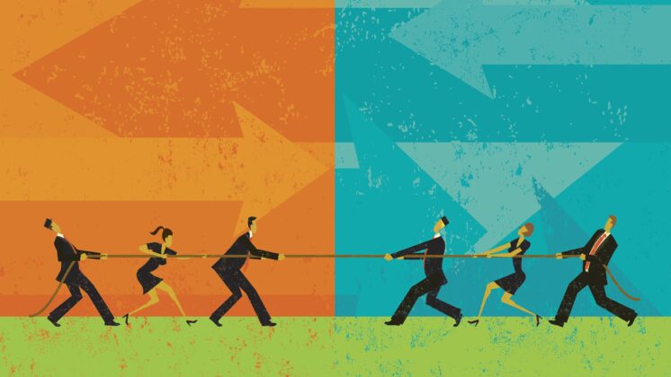 Businesspeople competing in in a tug-of-war battle on the great debates about leadership