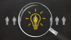 Magnifying glass shows a light bulb around the icon of a woman in a string of male icons