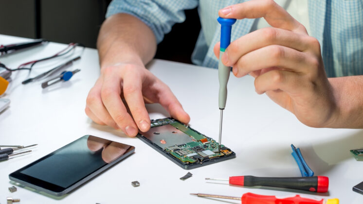 A person repairing a smartphone—an important element of sustainable technology