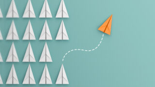 5 Leadership Lessons for a Better Career and Company A golden paper airplane flies away and up from a unit formation of white counterparts, showing the power of meaningful leadership lessons