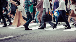 Young people hurry across a crosswalk on the way to their offices, showing growing diversity in the Japanese workplace