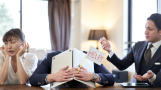 Cross-Cultural Barriers at Work & How to Overcome Them Man sits between two frustrated coworkers trying to overcome cross-cultural communication barriers