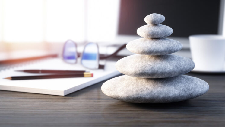 Stack of pebbles on a workplace desktop show how Japanese values impact business philosophy