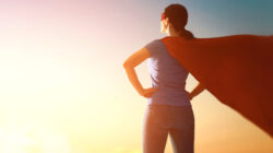 A female leader in business wearing a superhero cape.